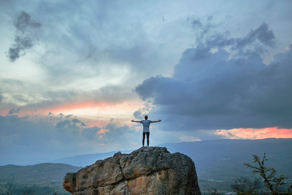 man on rock in nature sunset, self love,